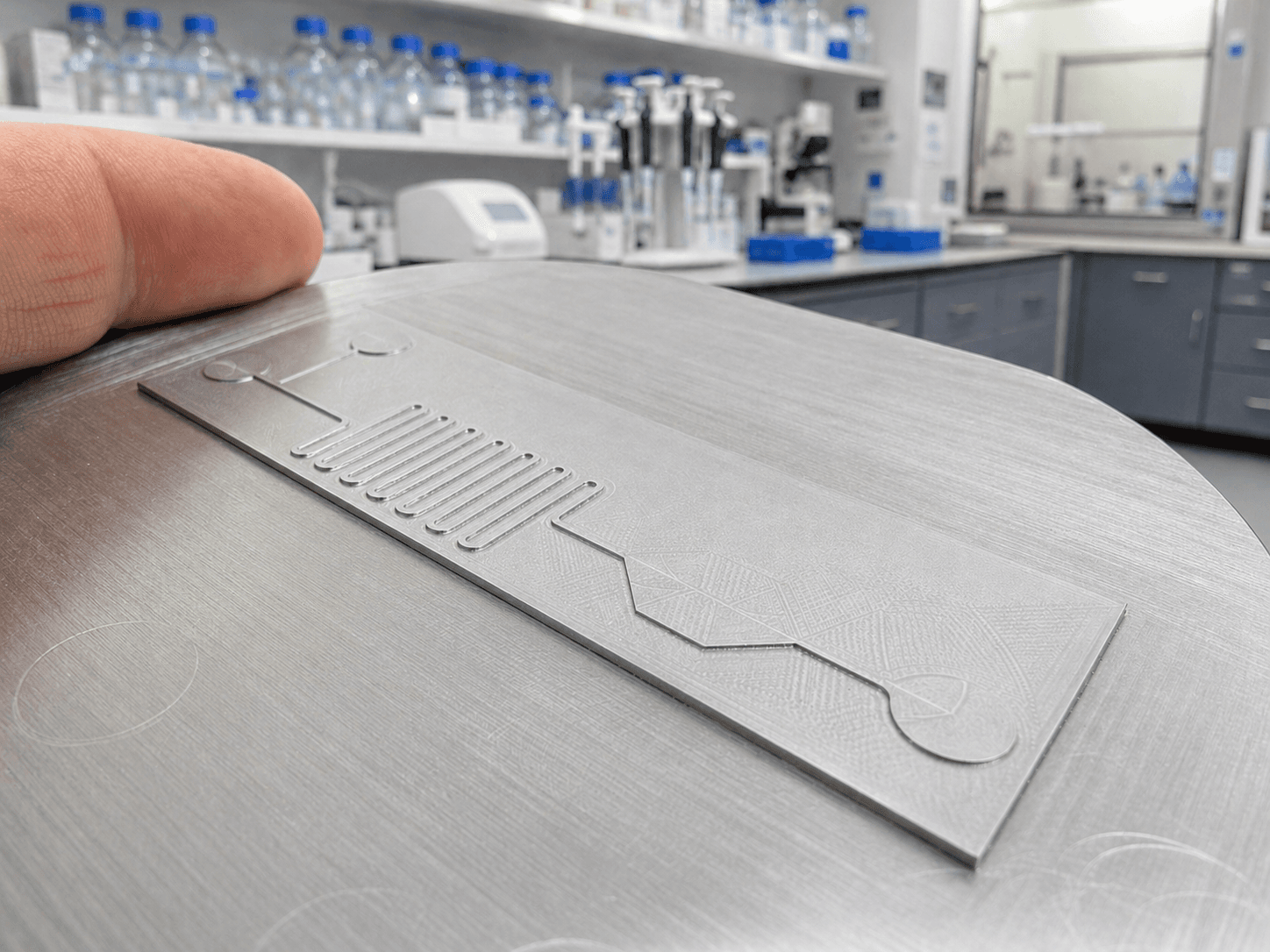CNC-machined aluminium mould for PDMS casting, held in a microfluidics lab
